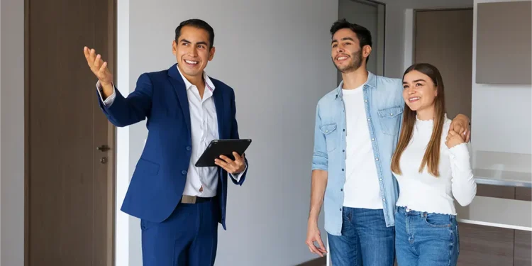 pareja joven medio hablando agente inmobiliario de frente